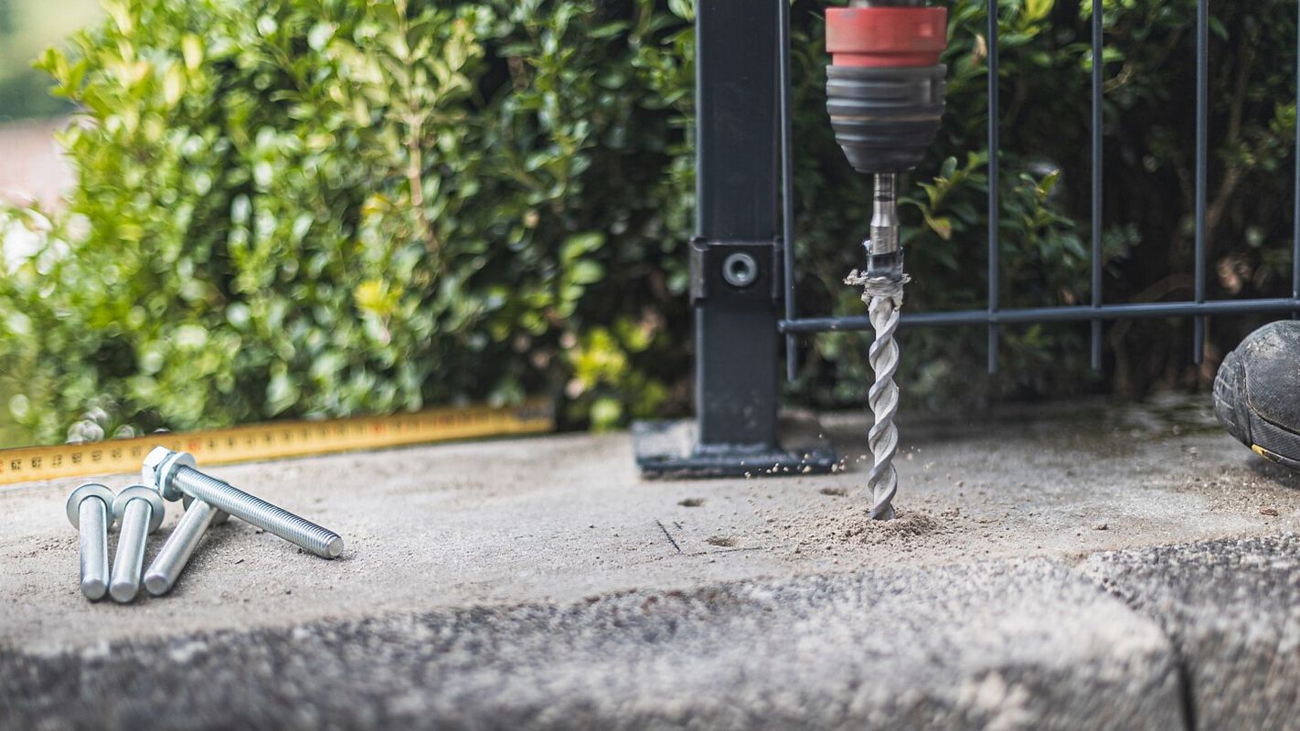 Die Löcher für die Schrauben werden in den Betonboden gebohrt